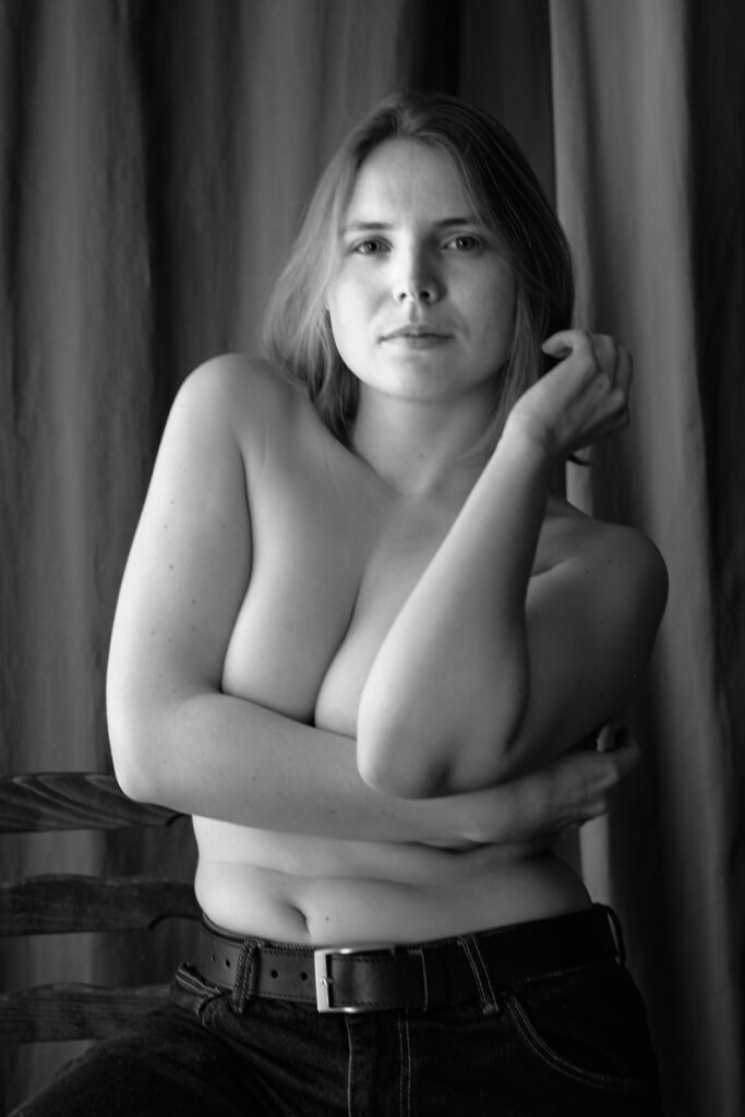 Eine junge Frau in Jeans mit nacktem Oberköper