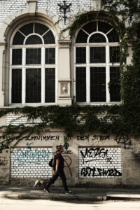 Streetphotography Stuttgart, eine Frau geht vor einer Fassade