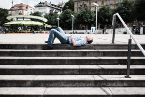 Streetphotography Stuttgart, ein Mann liegt auf einer Treppe