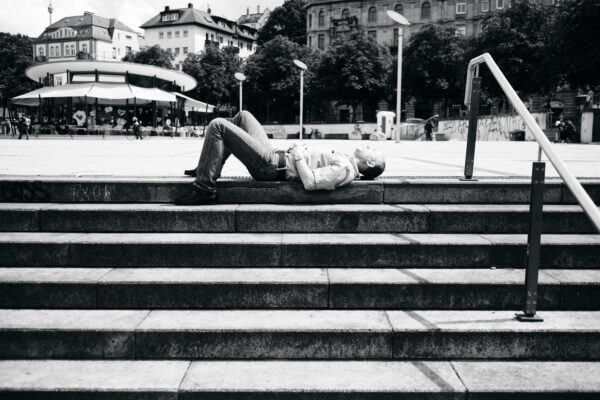 Streetphotography Stuttgart, ein Mann liegt auf einer Treppe