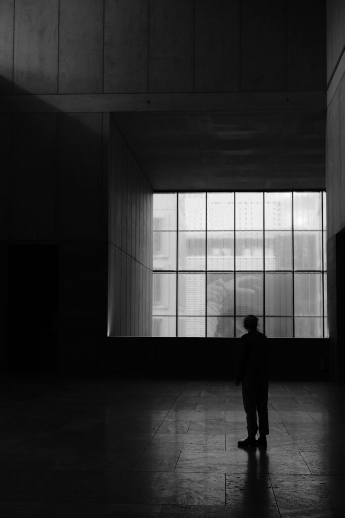 Die Silhouette einer Person vor einer Fensterwand in einem Museum