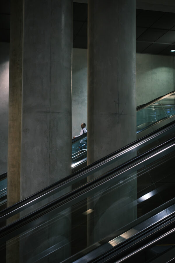 Street Fotografie mit einem Mann auf einer Rolltreppe