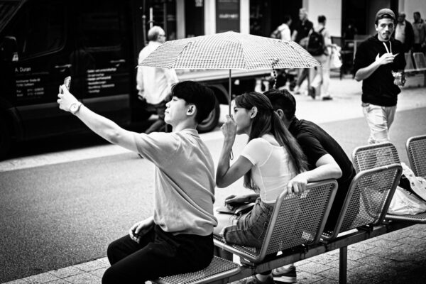 Street Fotografie zeigt Gruppe mit Selfie-Fotograf